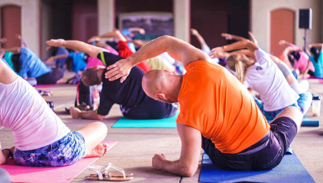 many people doing yoga in a room