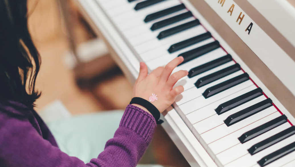 A kid is playing the piano