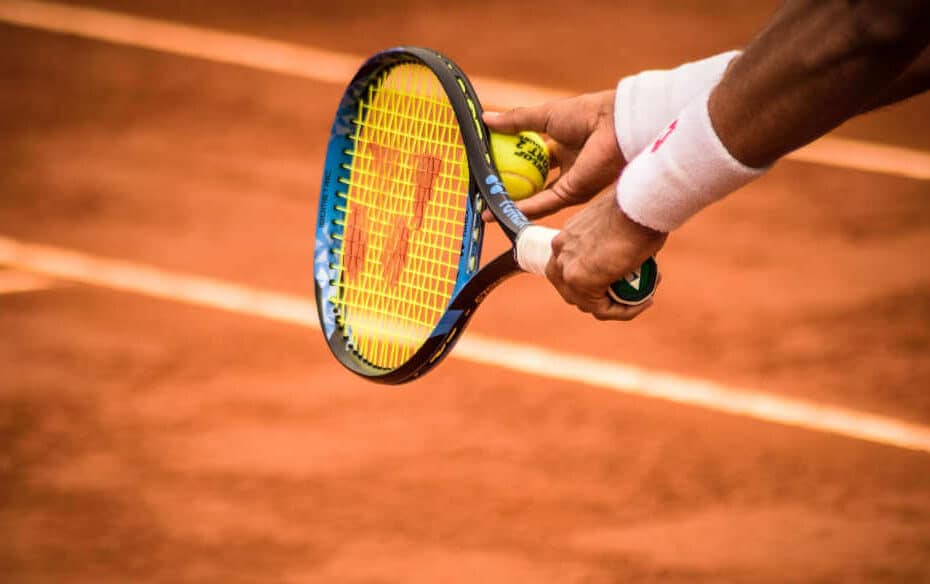 Tennis player is serving with his left hand on clay court