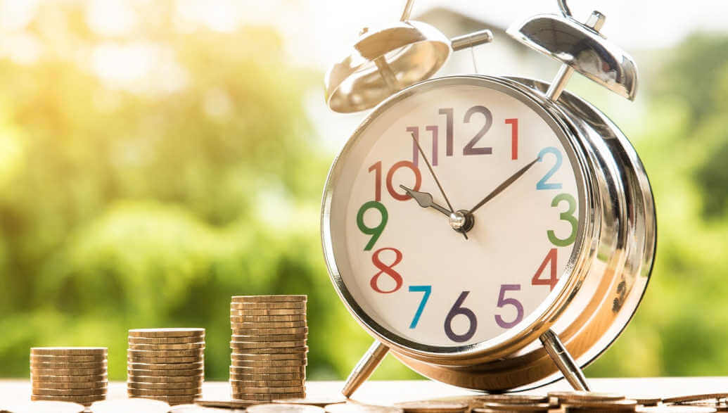 Money and an alarm clock displayed on a table.