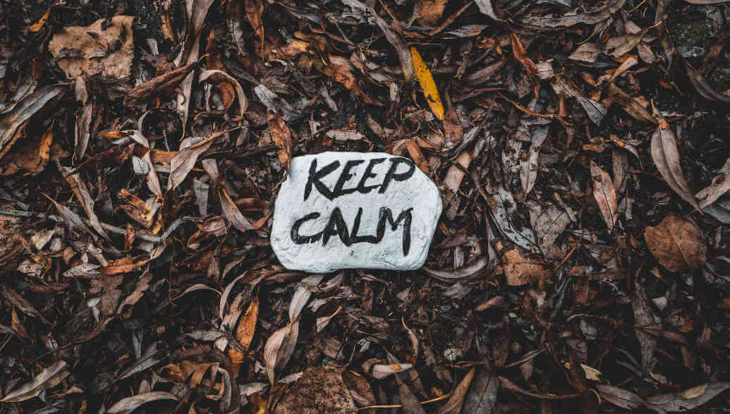 Ein "Keep Calm"-Stein liegt auf dem Laub.